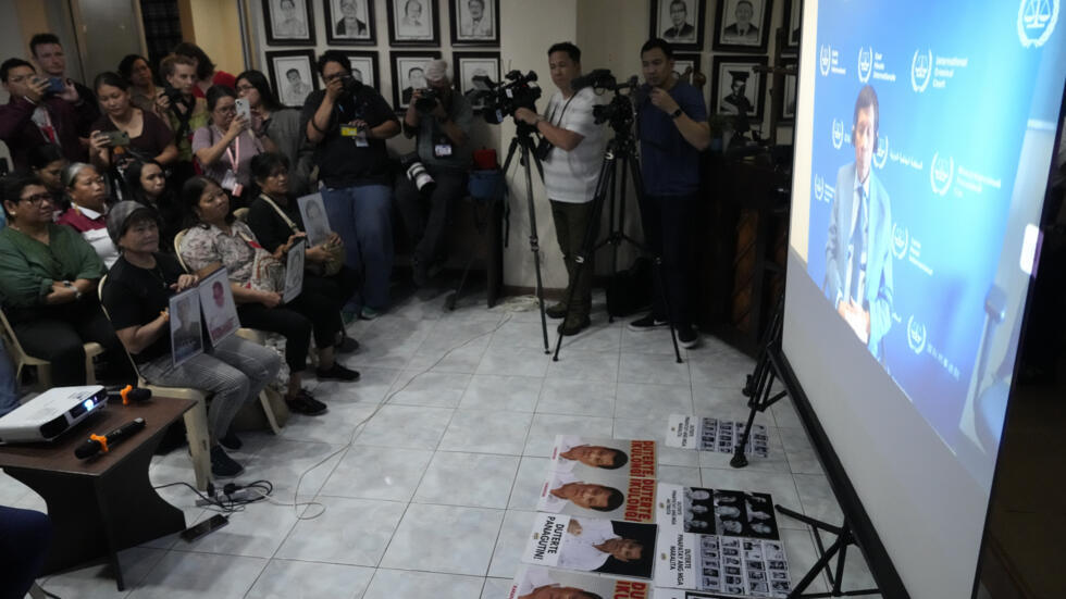 Người thân của các nạn nhân trong cuộc chiến chống ma túy của cựu tổng thống Philppines Rodrigo Duterte và các nhà hoạt động tại thành phố Quezon, Philippines, ngày 14/03/2025, theo dõi buổi phát sóng về phiên tòa đầu tiên xử ông Duterte tại Tòa án Hình sự Quốc tế. 