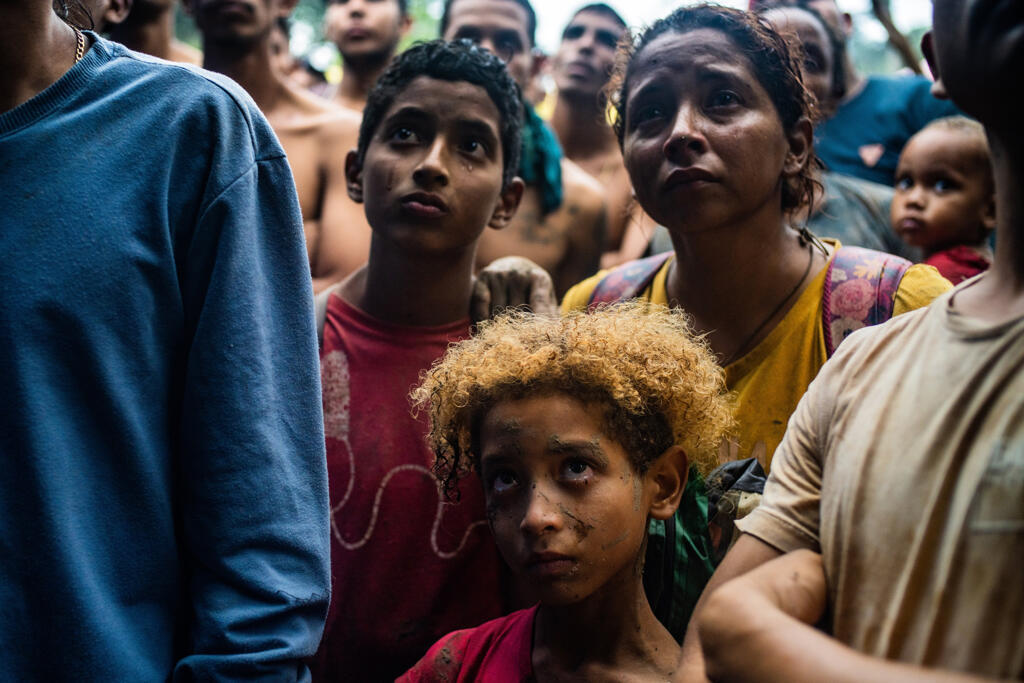 Sebastian Colmenares, 8 anos, chora ao ouvir o chefe comunitário de El Abuelo dizer ao grupo que a travessia da selva terminou. Atrás dele, o irmão Juan, 10 anos, e a mãe, Elgymar Galinde também ficam muito emocionados de saber que deixaram a floresta para trás.