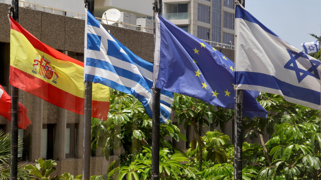 As bandeiras israelense (à direita) e espanhola (à esquerda) tremulam do lado de fora do prédio que abriga os escritórios da Embaixada da Espanha em Tel Aviv, em 22 de maio de 2024