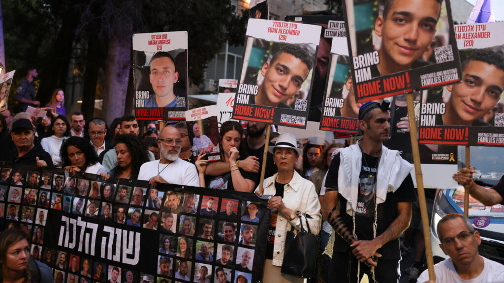 Des parents et des sympathisants des otages israéliens pris par des militants palestiniens lors de l'attaque du Hamas du 7 octobre et détenus à Gaza, tiennent des images de leurs proches lors d'une manifestation appelant à leur libération devant la résidence du Premier ministre Benjamin Netanyahu à Jérusalem, le 7 octobre 2024.