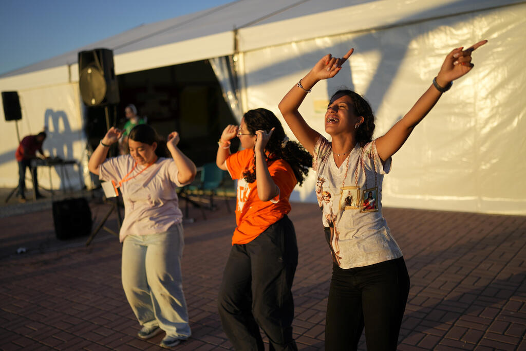 Meninas dançam ao som de músicas cristãs antes de participar de uma vigília à margem da Jornada Mundial da Juventude, em Almada, em Portugal, em 28 de julho de 2023.