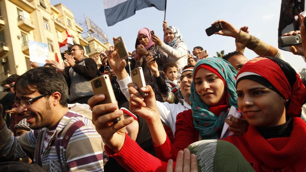Egyptians use their mobile phones to record celebrations on 12 February 2011 in Cairo's Tahrir Square.