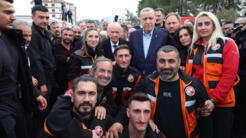 Le président turc Recep Tayyip Erdogan et, à ses côtés, le chef du parti nationaliste MHP Devlet Bahçeli, posent avec des membres de l'équipe de secours au centre de coordination de l'Afad à Adıyaman, ce lundi 27 février 2023.