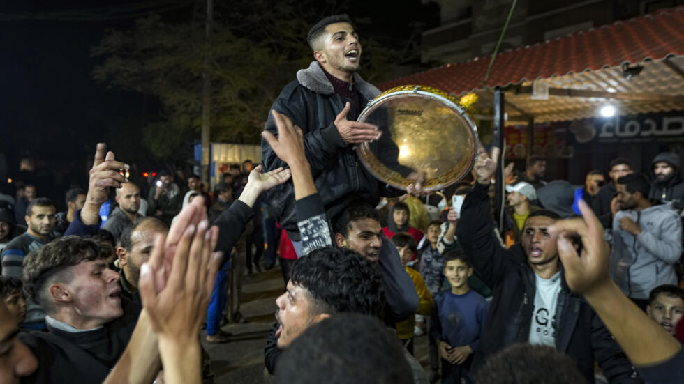 Palestinians celebrate the announcement of a ceasefire deal between Hamas and Israel in Deir al-Balah, central Gaza Strip, Wednesday, Jan. 15, 2025.