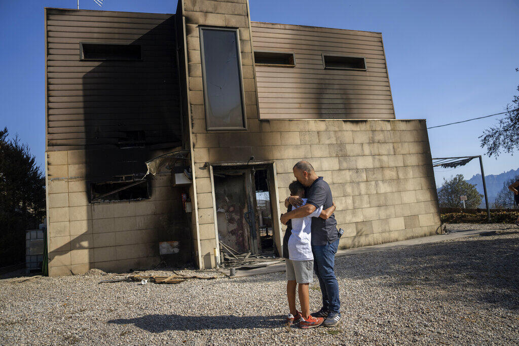 Diante da inércia do poder público, os casos de eco-ansiedade podem se tornar mais comuns no futuro. Moradores se abraçam diante da casa atingida por um incêndio.