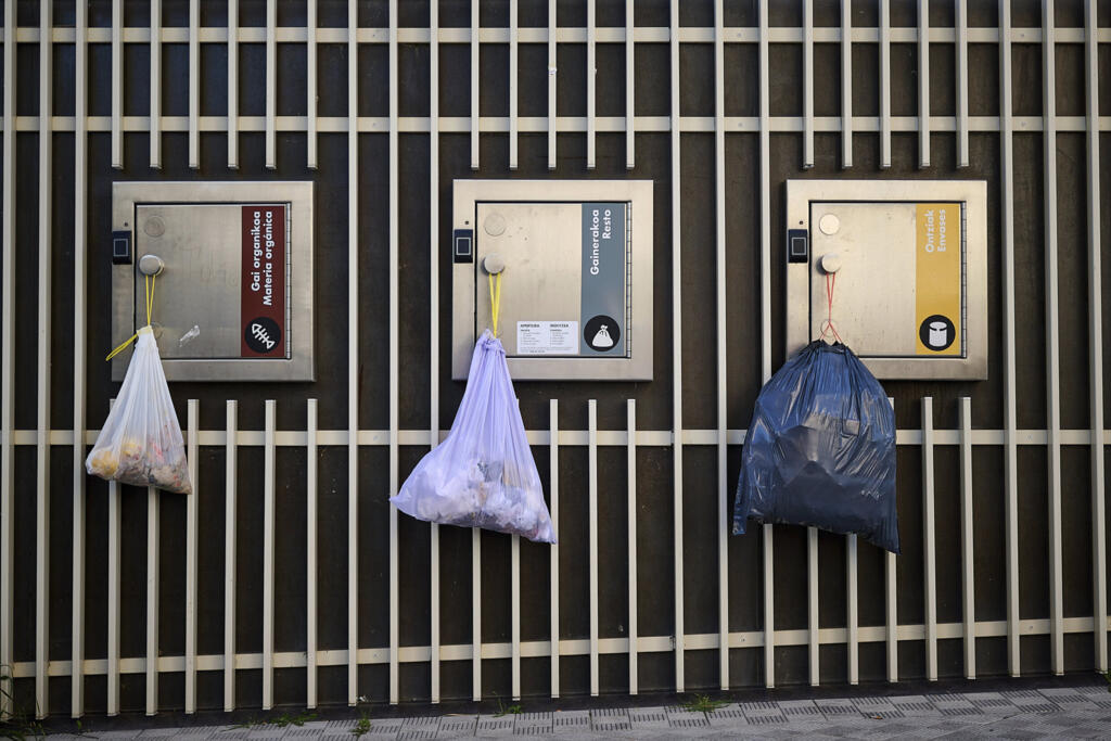 Sacos de lixo pendem das portas de coletores de reciclagem elétrica durante um apagão de grandes proporções em Pamplona, no norte da Espanha, na segunda-feira, 28 de abril de 2025. (Foto: AP/Miguel Oses)