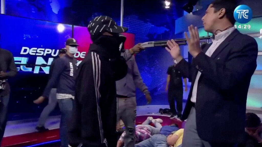 Un homme cagoulé pointe une arme sur le présentateur de télévision équatorien José Luis Calderon alors qu'il était en ondes à l'intérieur de la chaîne de télévision TC d'Équateur, à Guayaquil, en Équateur, le 9 janvier 2024, dans cette capture d'écran d'une vidéo.