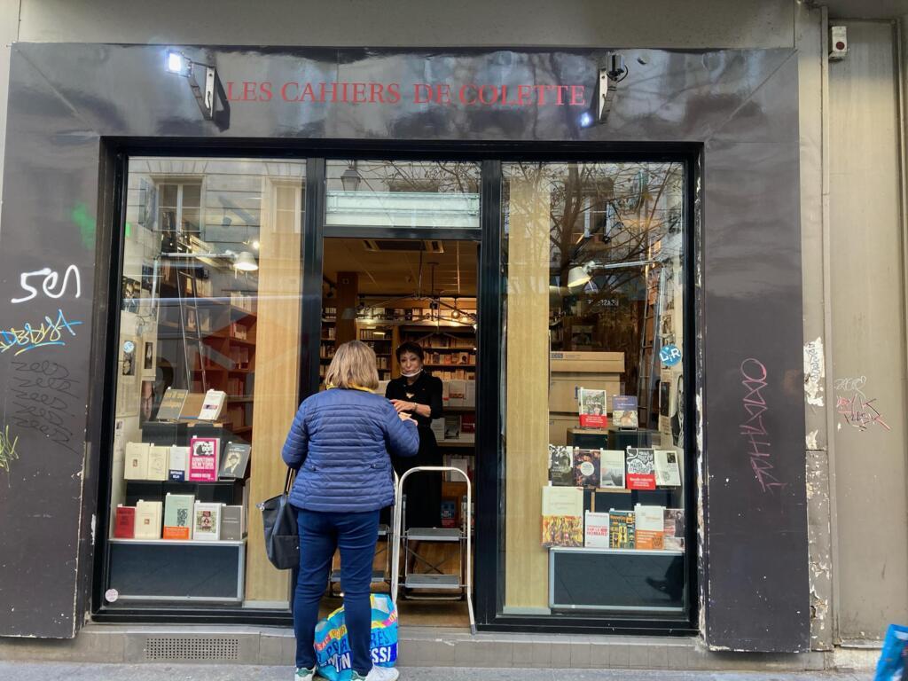 Colette Kerber, da livrarria "Les Cahiers de Colette", antende uma cliente que encomendou um livro pelo "click&collect".
