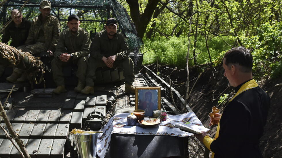 In this photo provided by Ukraine's 65th Mechanized Brigade press service, a chaplain conducts an Easter service for soldiers to mark Easter on the frontline in the Zaporizhzhia region, Ukraine, Sunda