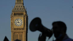 Un manifestante con un megáfono grita consignas frente al Big Ben mientras las enfermeras del cercano Hospital St. Thomas protestan en Londres, el lunes 6 de febrero de 2023.