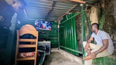 Au coin télé de La Camayenne, à Conakry, des jeunes regardent le procès du massacre du stade, le 17 novembre 2022.
