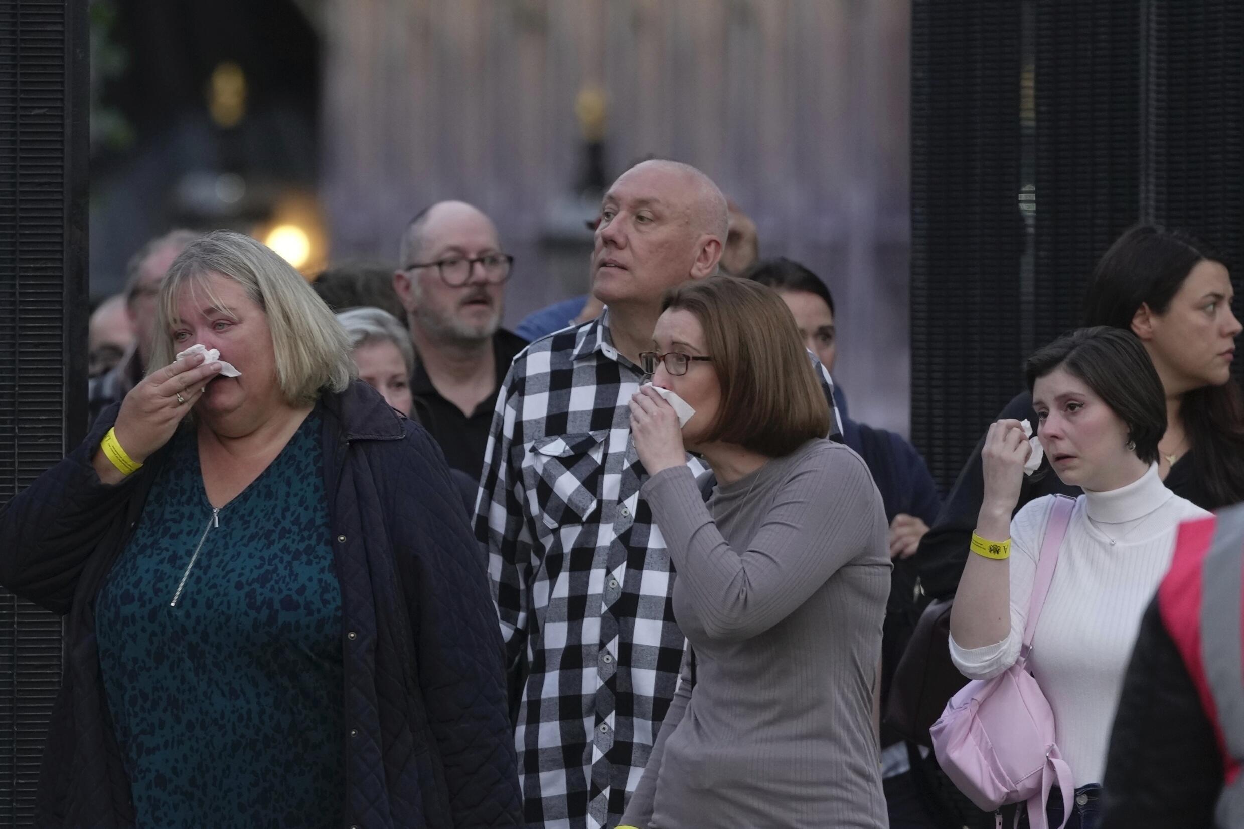 Les gens pleurent en quittant Westminster, à Londres, mercredi 14 septembre 2022.