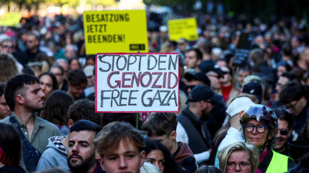 Muandamanaji akiwa na bango lenye maandishi "Simamisha mauaji ya halaiki, huru Gaza" wakati wa mkutano wa huko Berlin, Ujerumani. September 27, 2025.  REUTERS/Christian Mang