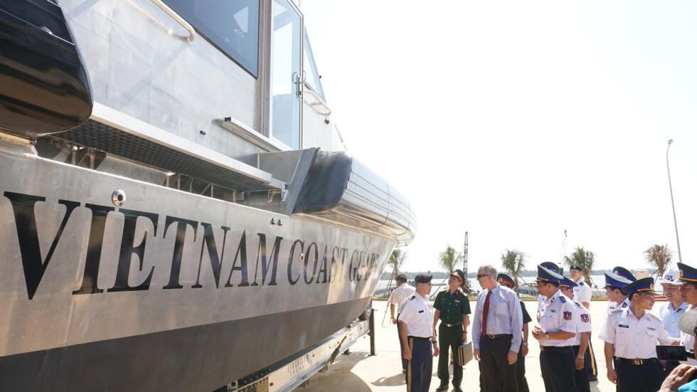 U.S. Ambassador Ted Osius, fourth from left, inspects patrol boats with Vietnam Coast Guard members during a delivery ceremony, Monday, May 22, 2017.