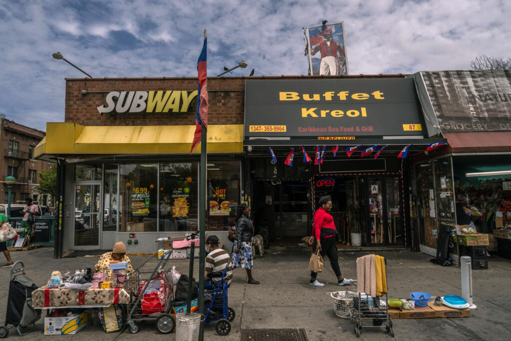 Pessoas caminham e vendem produtos no bairro Little Haiti, em 8 de junho de 2025, no distrito do Brooklyn, na cidade de Nova York.
