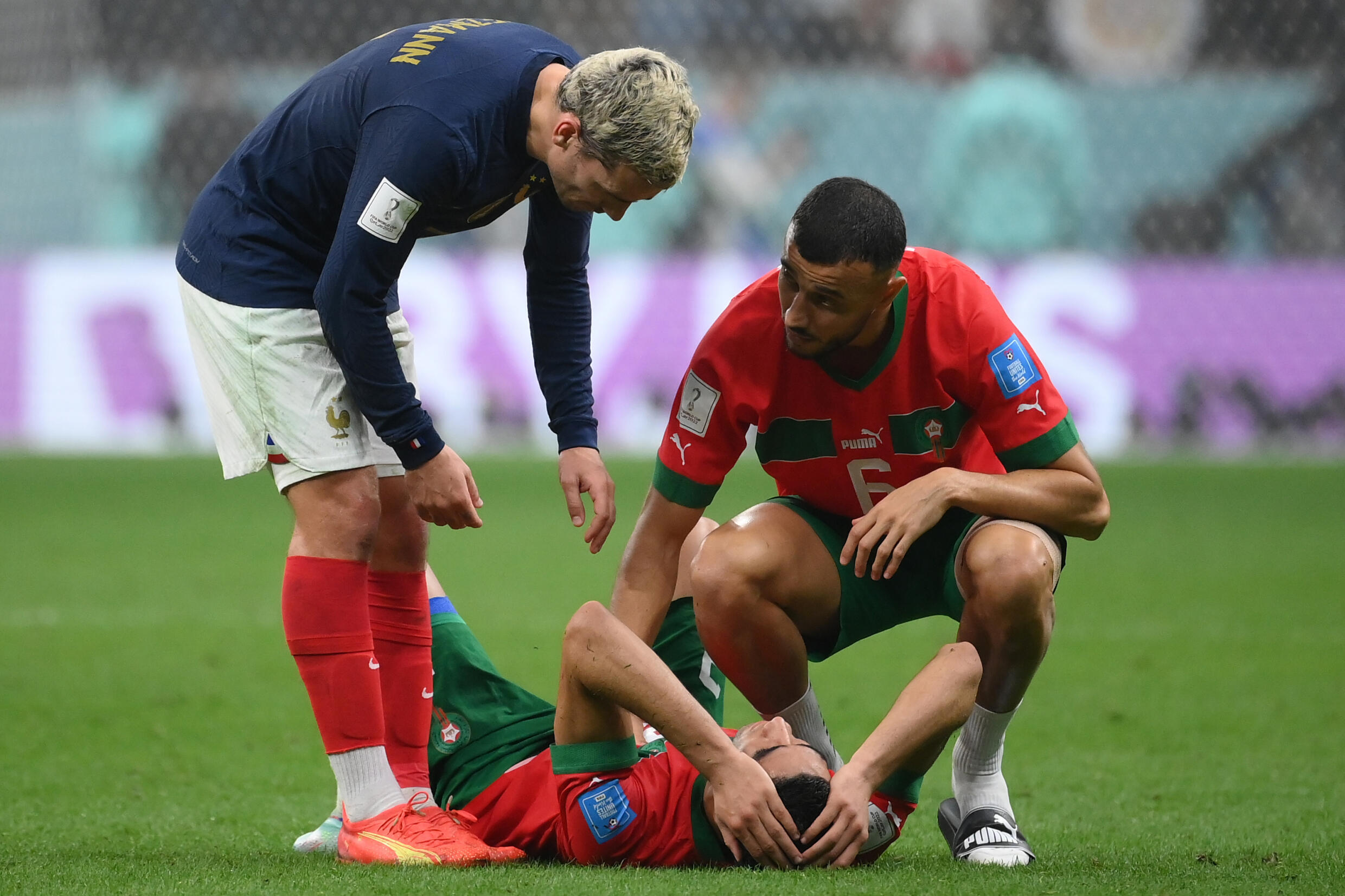 El delantero de Francia Antoine Griezmann y el defensor de Marruecos Romain Ghanem Saiss consuelan al defensor de Marruecos Achraf Hakimi después del partido de fútbol de semifinales de la Copa del Mundo de Catar 2022 entre Francia y Marruecos en el Estadio Al-Bayt en Al Khor, al norte de Doha el 14 de diciembre de 2022.