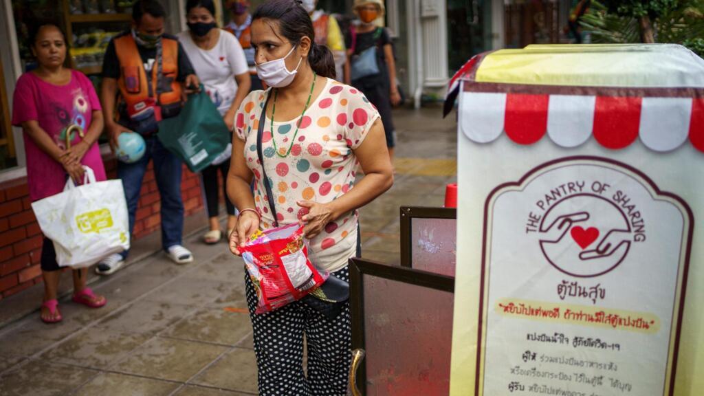 Des personnes font la queue pour recevoir de la nourriture gratuitement à Bangkok, en Thailande pays touristique durement touché économiquement par le coronavirus.