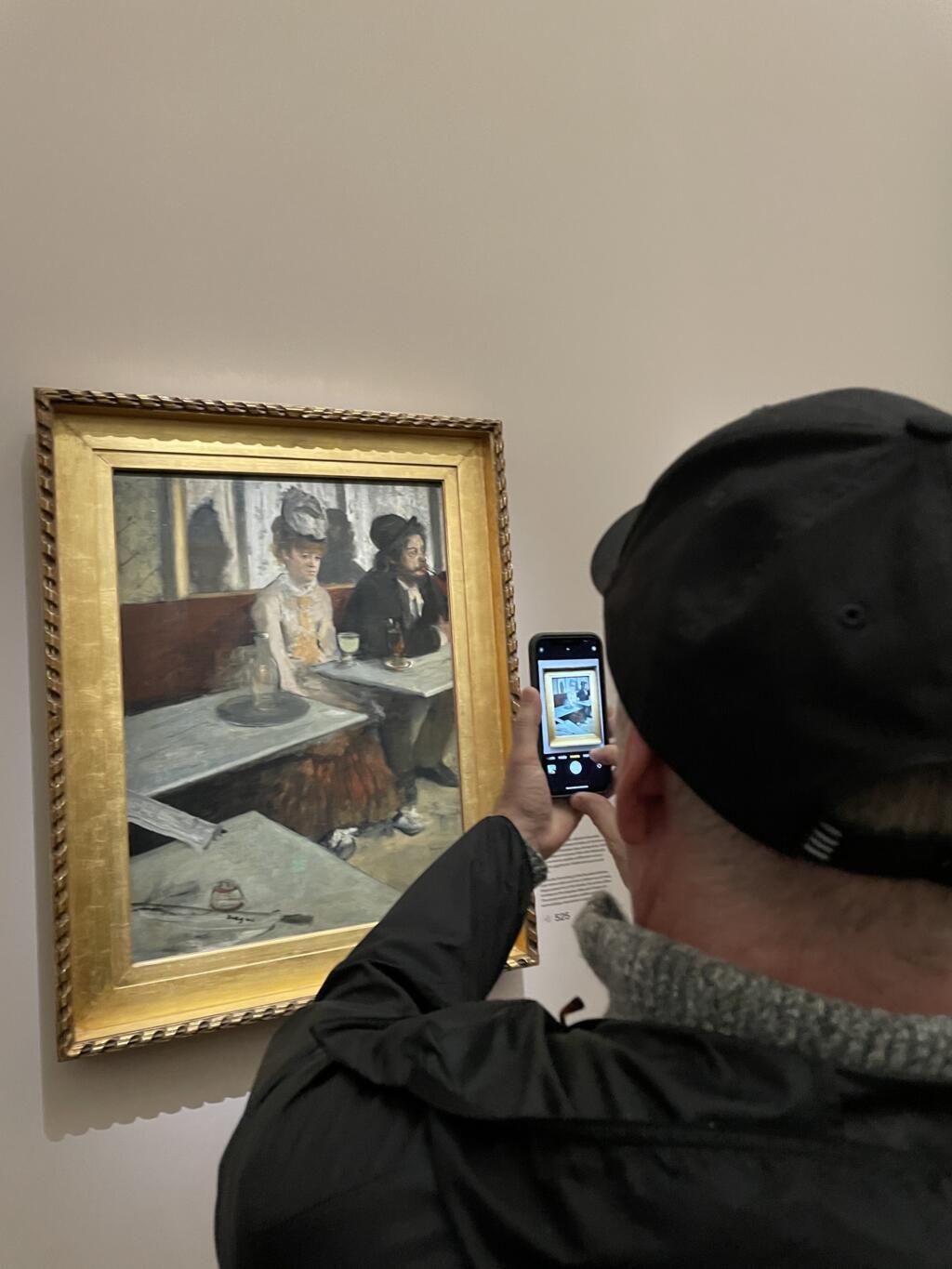 Visitante tira foto de "O Absinto", de Edgard Degas, no Museu d'Orsay, em Paris (28/04/23).