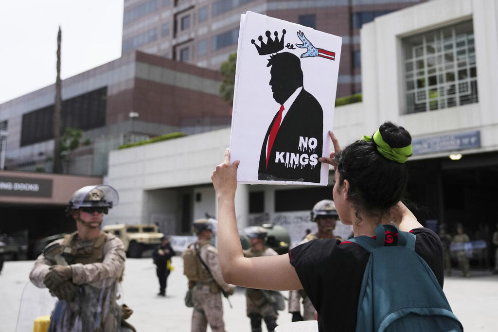 Жінка тримає плакат з написом «Ні королям» під час антитрампівських протестів у Лос-Анджелесі, 14 червня 2025