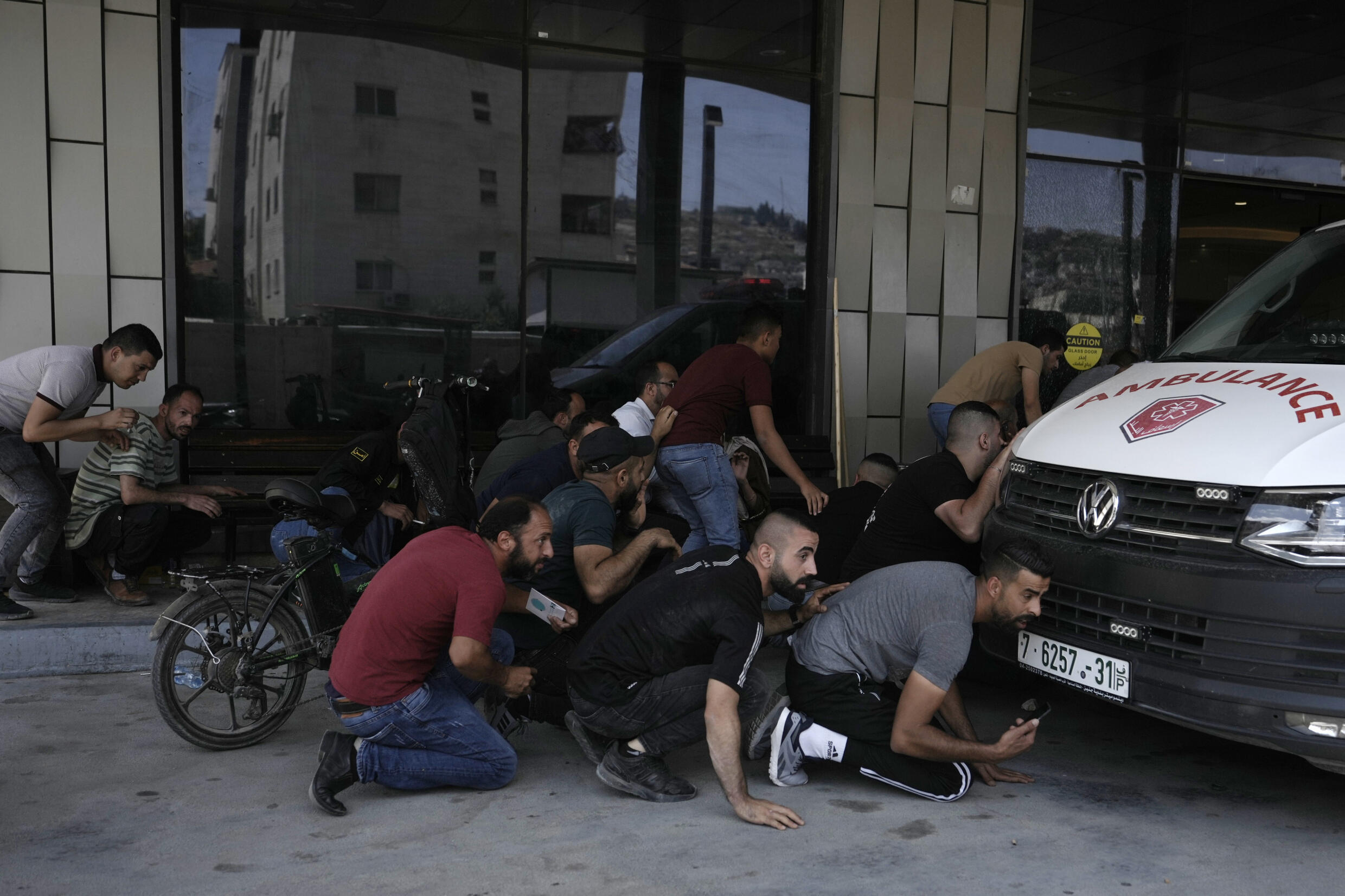 Palestinos se protegem durante bombardeios em Jenin, na Cisjordânia ocupada.