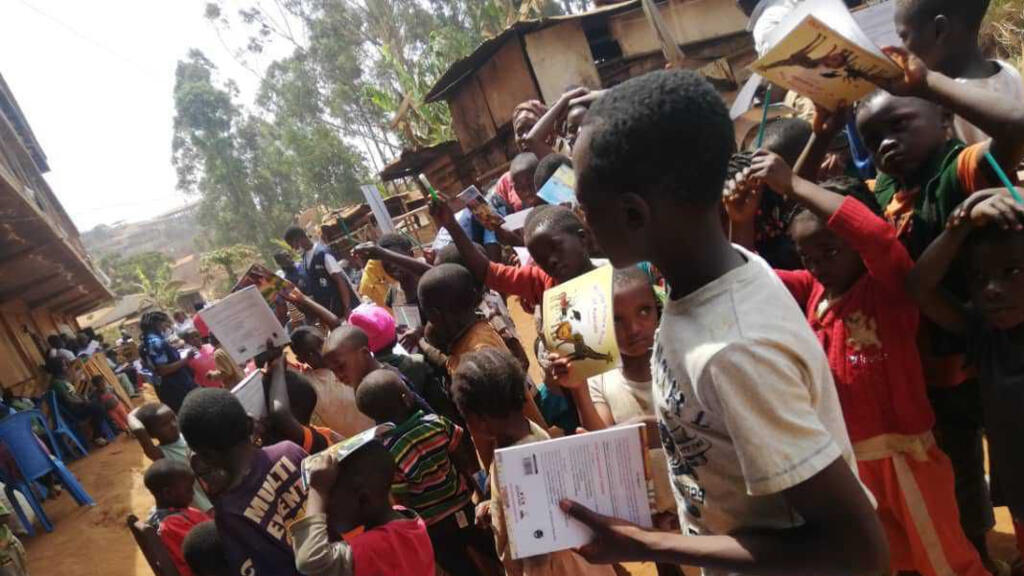 Distribution de livres à Dschang, dans le camp de déplacés du quartier Tsinkop au Cameroun.