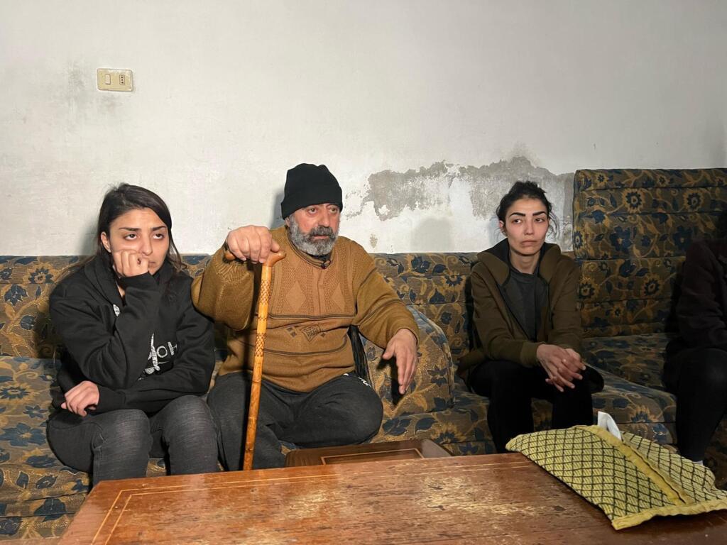 Abou Bashar, qui a perdu ses deux fils, est entouré de sa fille (gauche) et sa nièce (droite).