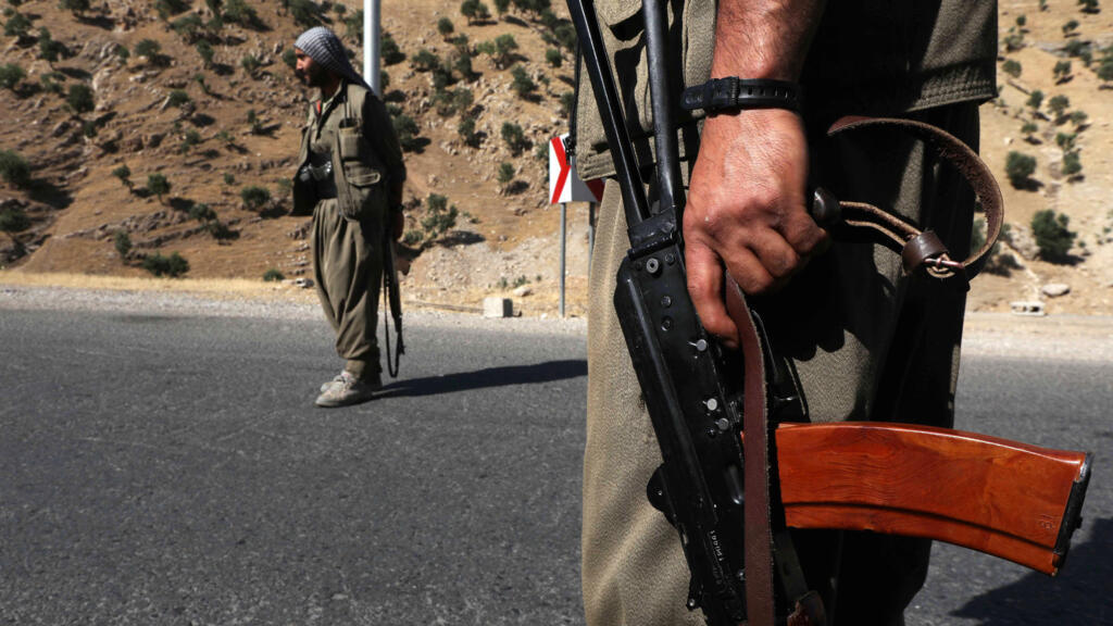 A member of the Kurdistan Workers' Party (PKK) carries an automatic rifle on a road in the Qandil Mountains in northern Iraq.