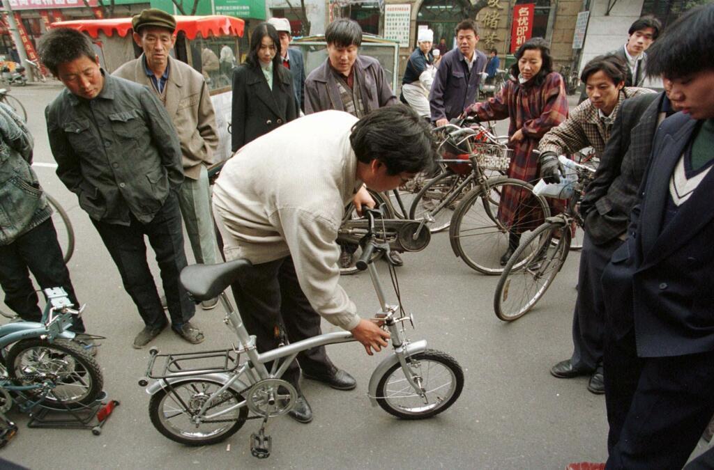 Chine, dans un magasin de Pékin, le vendeur montre comment démonter son (mini)vélo.