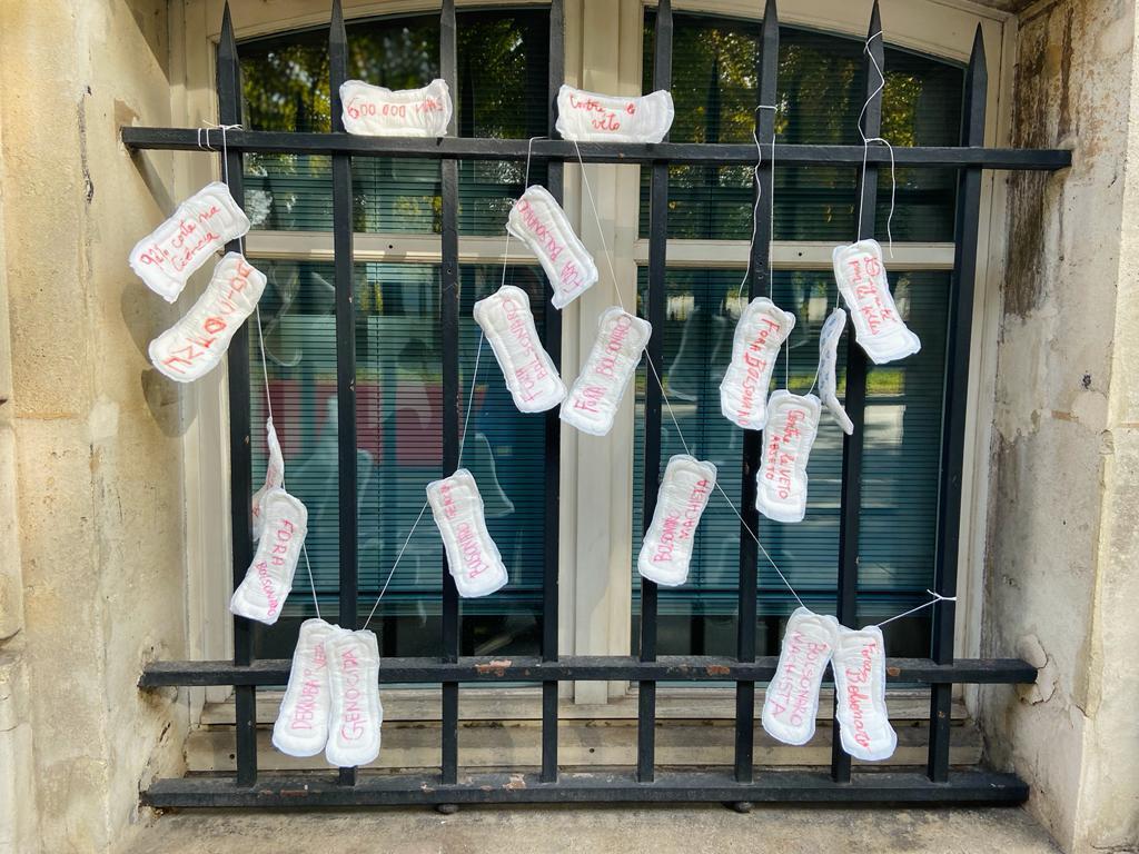 Brasileiras pregaram absorventes nas grades da fachada da embaixada brasileira em Paris para protestar contra veto do presidente Jair Bolsonaro a artigos que determinam a distribuição gratuita do produto para população precária