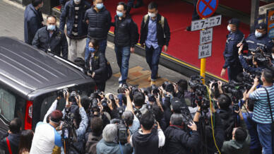 Tổng biên tập Stand News, ông Lâm Thiệu Đồng (Patrick Lam), thứ 4 từ trái, bị cảnh sát bắt giải đi ngày 29/12/2021. Đây là vụ bố ráp cuối cùng trong năm, dùng luật an ninh Trung Quốc đánh vào vào tự do báo chí Hồng Kông.