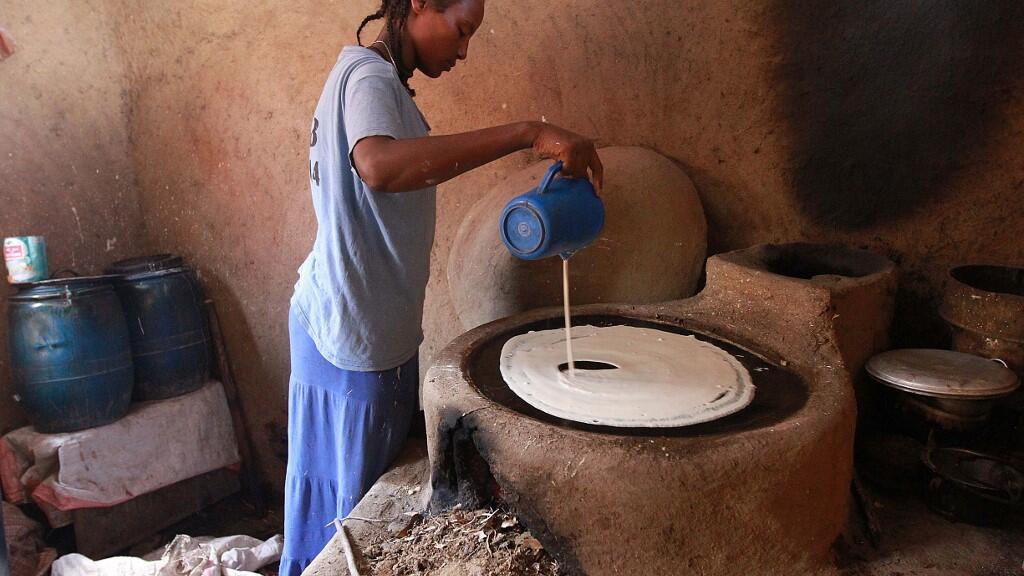 Une jeune éthiopienne prépare l'injera une galette faite à partir de farine de teff.