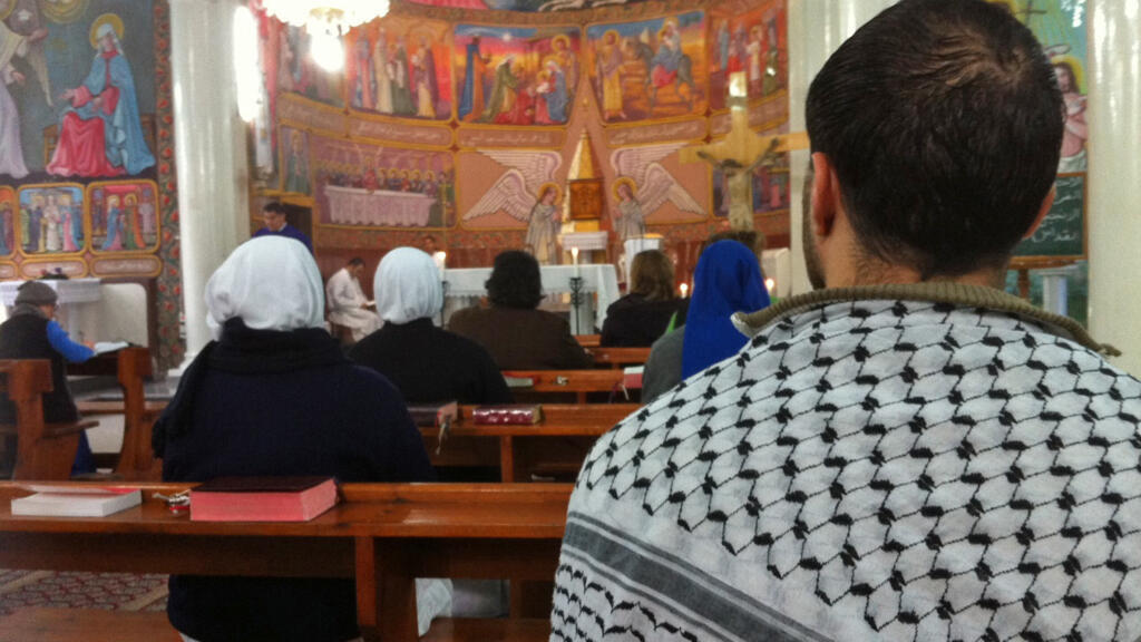 Des chrétiens célébrant la messe dominicale à l'église de la Sainte-Famille de Gaza.