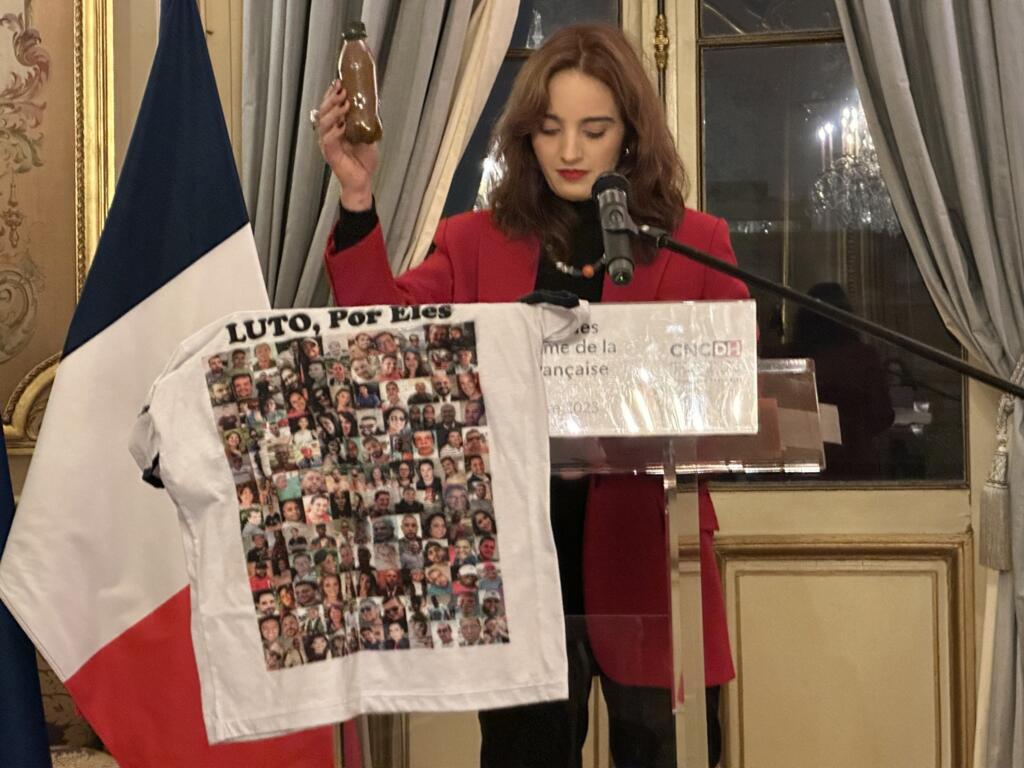 Marina Paula mostra garrafa com "água de Brumadinho" e camiseta com fotos das vítimas da barragem em 25 de janeiro de 2019.