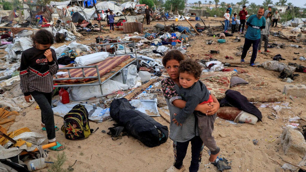 Des Palestiniens inspectent les dégâts sur le site d'une frappe israélienne sur un camp de tentes abritant des personnes déplacées, à Khan Younis, dans le sud de la bande de Gaza, le 18 mai 2025.