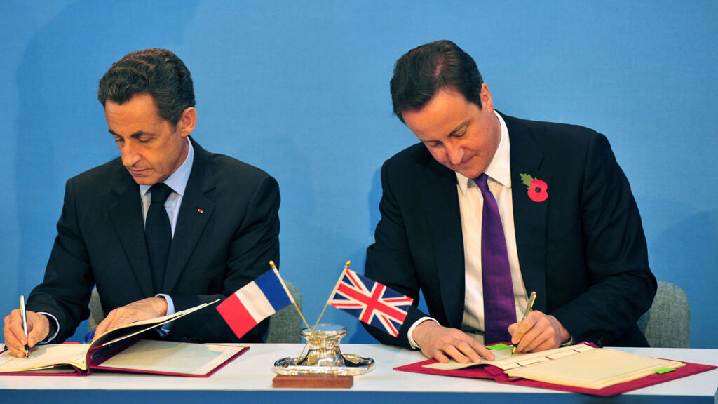 L'ex-président français Nicolas Sarkozy et l'ex-Premier ministre britannique David Cameron signent des traités lors du sommet Royaume-Uni-France à Lancaster House, à Londres en 2010.