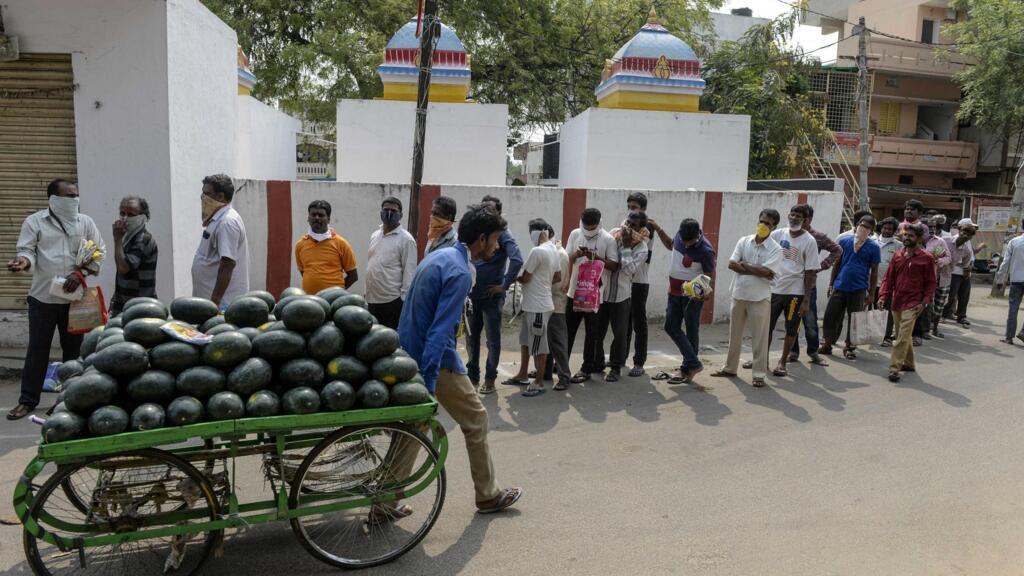 Des personnes font la queue pour recevoir du riz distribué gratuitement par le gouvernement, le 3 avril 2020.