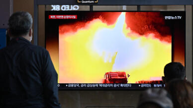 Des passagers regardent la retransmission de nouveaux tirs de missiles nord-coréens dans une station de Séoul, le 13 octobre 2022.