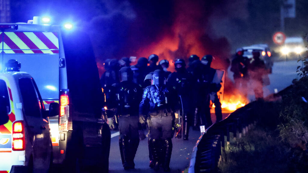 Des policiers marchent près de pneus en feu lors d'un blocage sur le périphérique, dans le cadre d'un mouvement de protestation populaire appelé « Bloquons Tout » appelant à des perturbations nationales toute la journée, à Nantes, en France, le 10 septembre 2025.