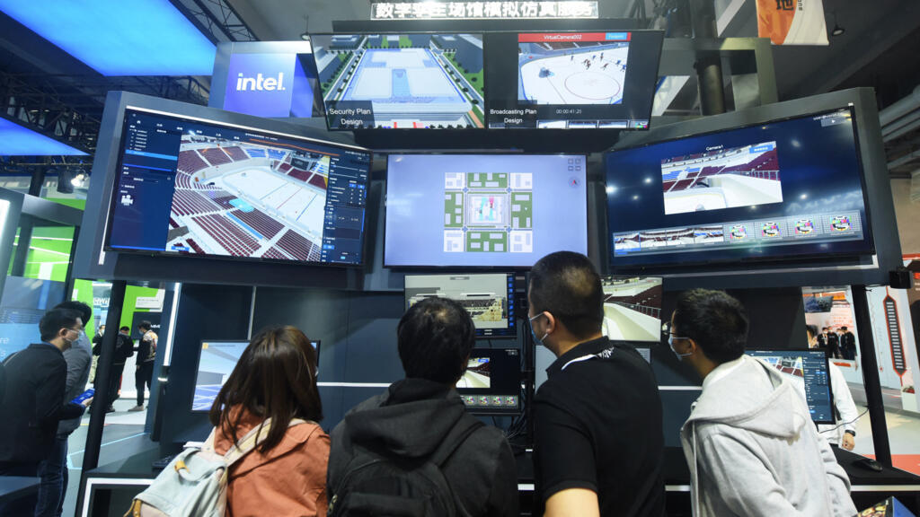 Des visiteurs regardent un système de service de simulation de jumeaux numériques pour les sites sportifs par Intel lors de la conférence Apsara, une conférence sur l'informatique en nuage et l'intelligence artificielle (IA), à Hangzhou, dans la province chinoise du Zhejiang (est), le 19 octobre 2021.