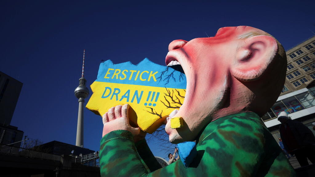 Une œuvre de l'artiste Jacques Tilly représentant le président Vladimir Poutine qui « mange » le drapeau ukrainien avec l'expression « Étouffe-toi », est mise en avant lors d'une manifestation anti-guerre à Berlin, le 13 mars 2022.