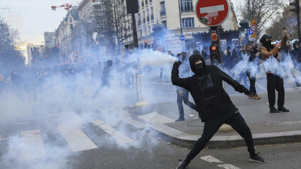 Manifestante atira bomba de gás lacrimogênio contra a polícia durante protesto contra a reforma da Previdência em Paris, em 23 de março de 2023.