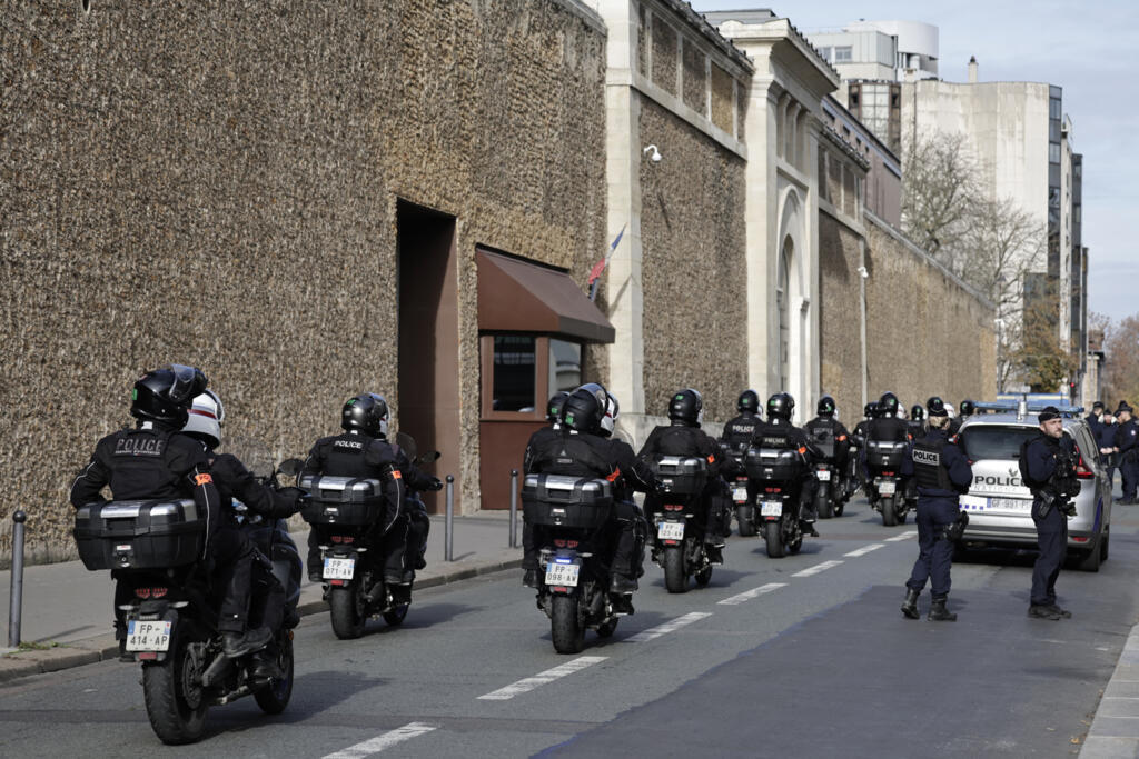 Policiais franceses passam em frente à entrada da prisão da Santé, em Paris, em 10 de novembro de 2025, onde o ex-presidente Nicolas Sarkozy está detido