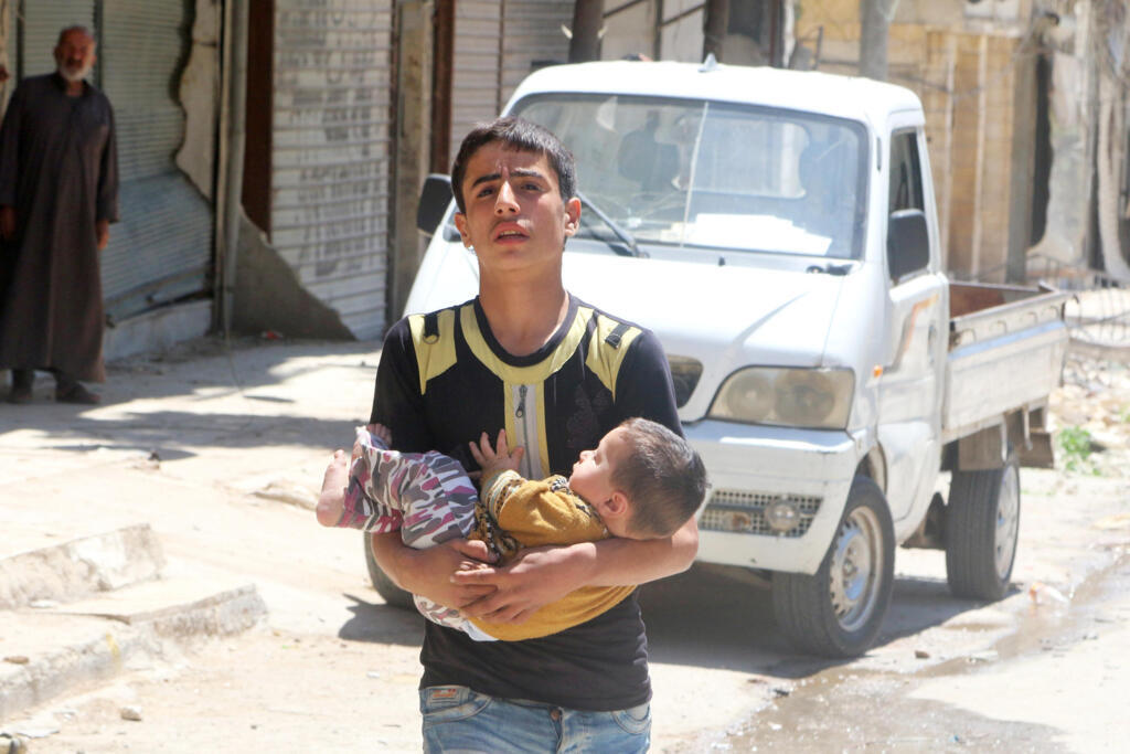 Mmoja wa wakaazi wa mji wa Aleppo akiwa amembeba mtoto aliyejeruhiwa