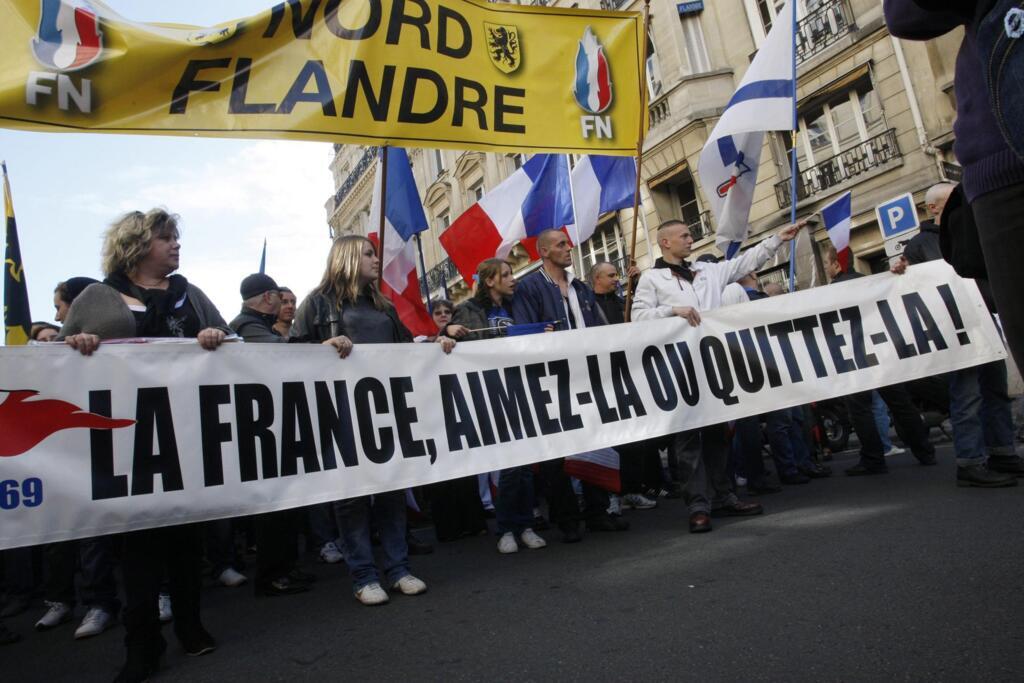 Manifestantes de extrema direita carregam faixa com dizeres: França, ame-a ou deixe-a .