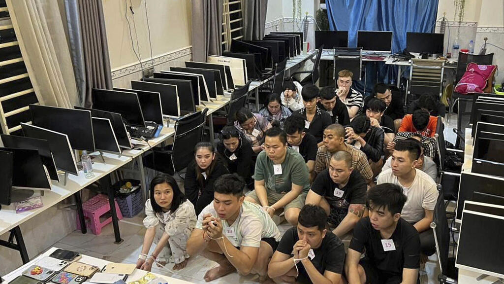 In this photo released by Agence Kampuchea Press (AKP), online scammers arrested by authorities squat in a building in Sihanoukville province, southwestern of Phnom Penh, Cambodia, Tuesday, July 15, 2