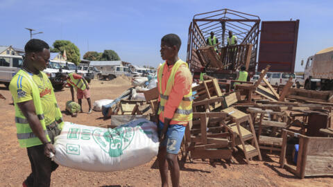 Men unload the belongings of Central African Republic (CAR) refugees from the Gado camp at a transit camp managed by United Nations High Commissioner for Refugees (UNHCR) in Beloko, CAR, on 2 December, 2020. 