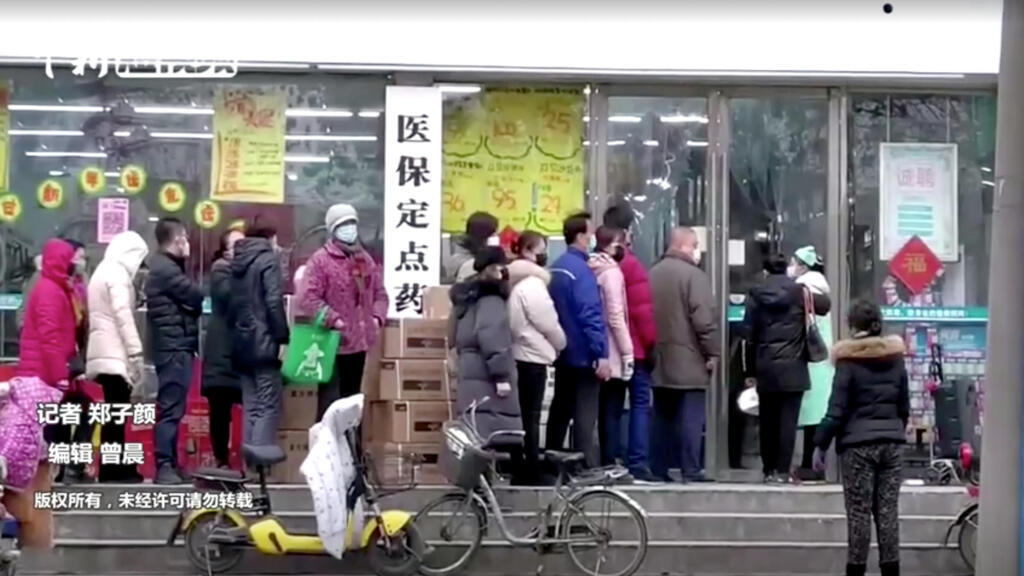 Des personnes portant des masques font la queue dans un magasin de Wuhan, dans la province de Hubei, en Chine, le 23 janvier 2020, sur cette image fixe tirée d'une vidéo.
