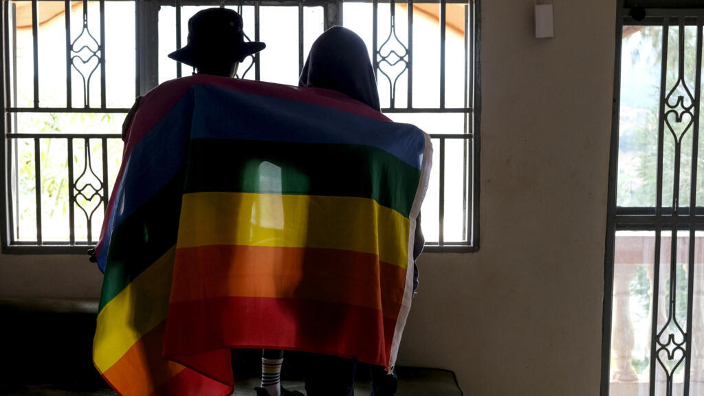 Un couple d'Ougandais se couvre d'un drapeau LGBT+ en Ouganda le 25 mars 2023.