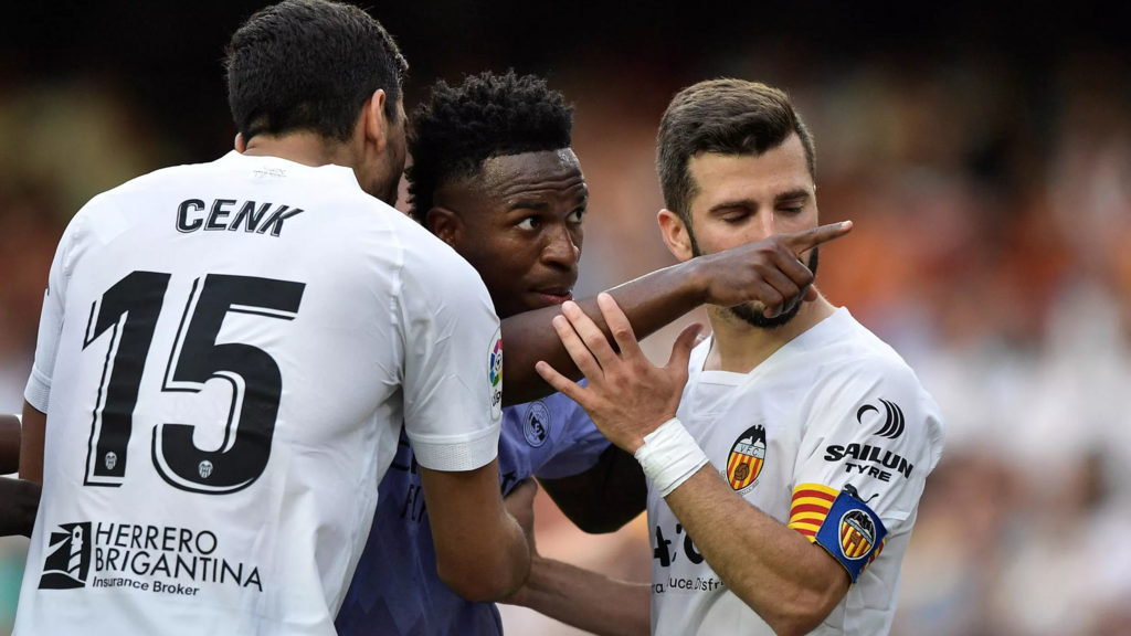 O jogador brasileiro Vinicius Jr. (centro) aponta para torcedores que o insultaram durante a partida entre o Real Madrid e o Valencia, em 21 de maio de 2023.