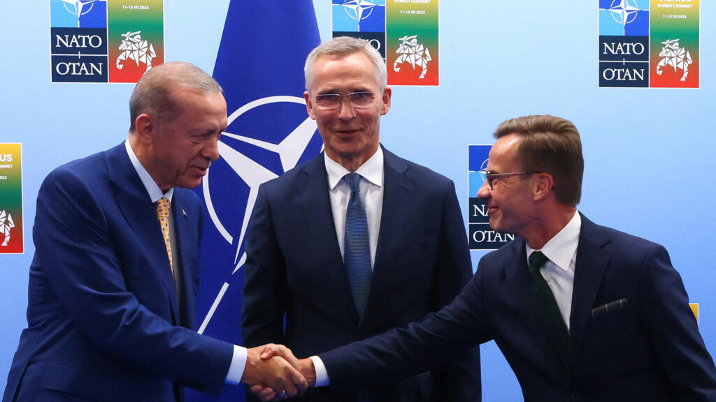 Turkish President Tayyip Erdogan and Swedish Prime Minister Ulf Kristersson shake hands next to NATO Secretary-General Jens Stoltenberg ahead of a NATO summit in Vilnius, Lithuania, on 10 July 2023.